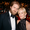 Man and woman in formal attire posing together at a formal event with blurred background