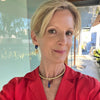 Woman wearing a red shirt with a blurred outdoor background