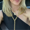 Woman with blonde hair and gold jewelry sitting in a car