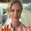 Woman wearing a colorful patterned blouse with a blurred outdoor background
