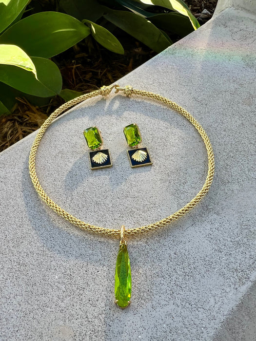 Jewelry set with green pendant and earrings on a stone surface