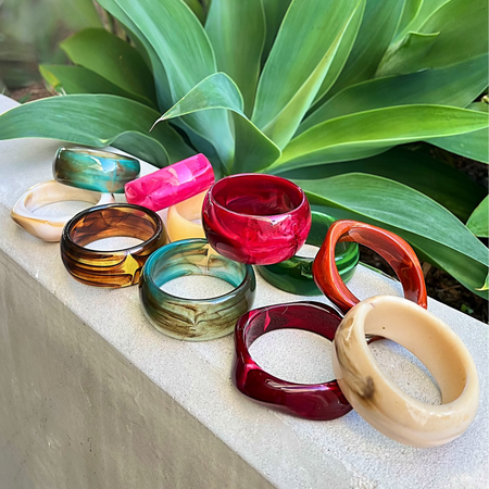 Colorful bangles on a stone surface with green plants in the background