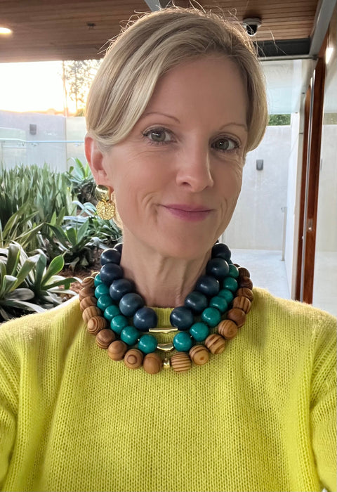 Woman wearing a colorful beaded necklace in an outdoor setting