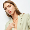 Woman wearing gold jewelry against a white background