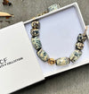 Beaded bracelet with decorative beads on a white box, featuring the 'Fusty F Collection' branding.