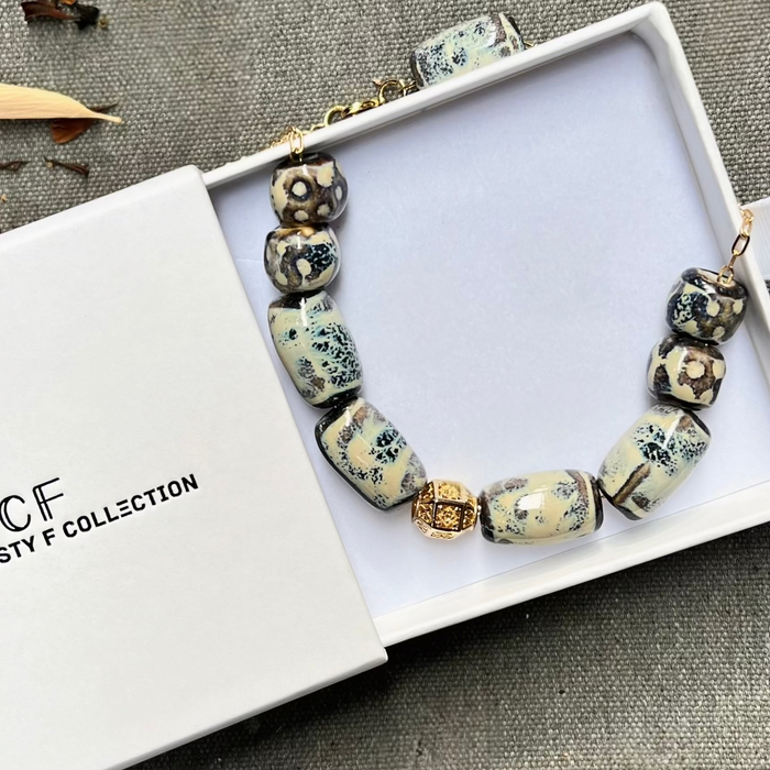 Beaded bracelet with decorative beads on a white box, featuring the 'Fusty F Collection' branding.