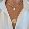 Gold necklaces with pendants on a white shirt background