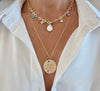 Gold necklaces with pendants on a white shirt background
