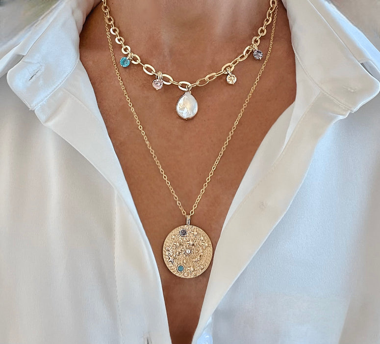 Gold necklaces with pendants on a white shirt background