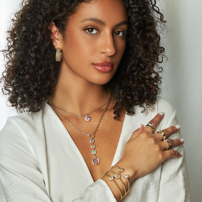 Woman wearing jewelry with a neutral background