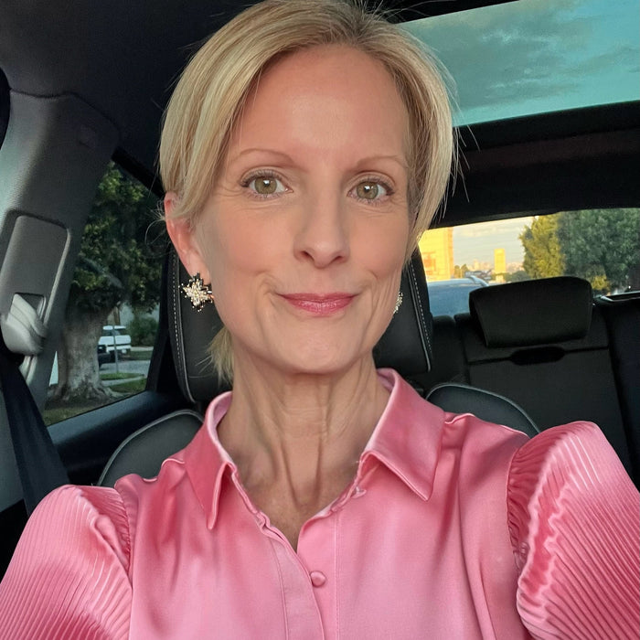 Woman in a pink shirt sitting inside a car with a scenic background