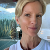 Woman wearing a white top with a blurred outdoor background