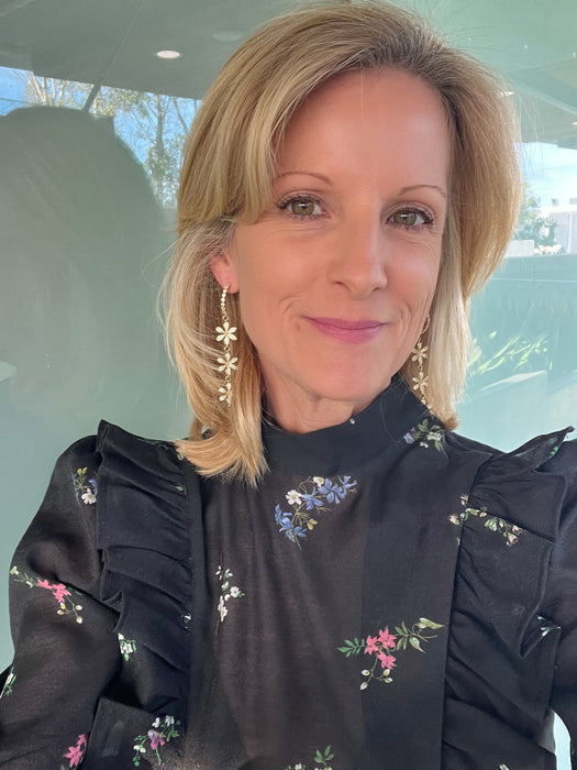 Woman wearing a black floral blouse indoors