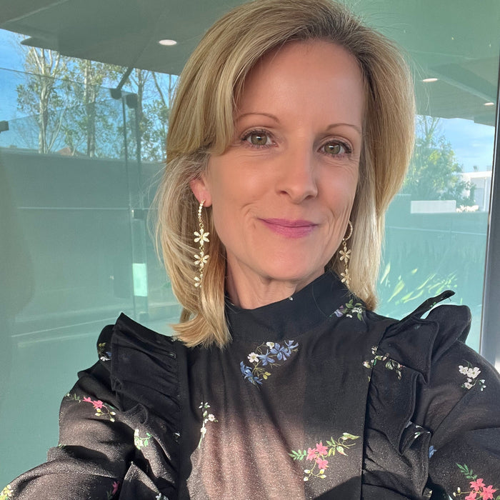 Woman wearing a black floral blouse with a blurred background