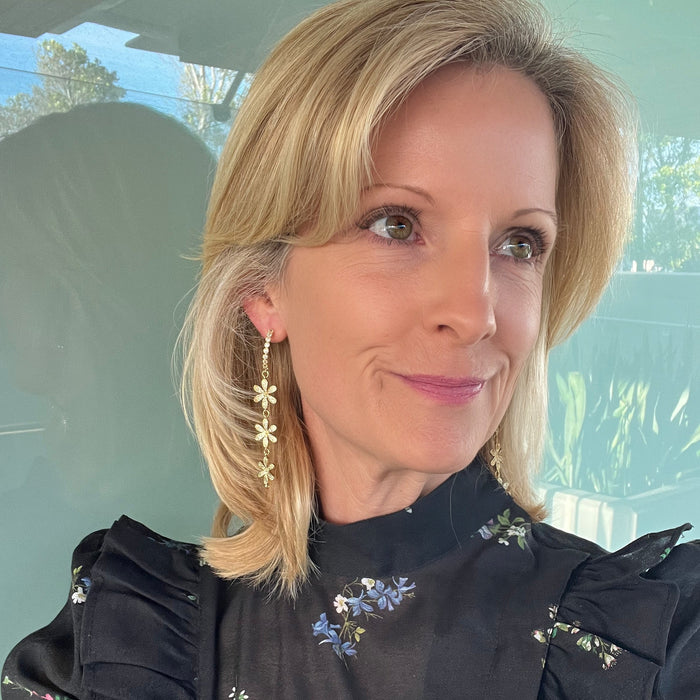 Woman wearing a black floral embroidered blouse indoors