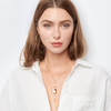 Woman wearing gold jewelry including a necklace, bracelet, and ring on a white background