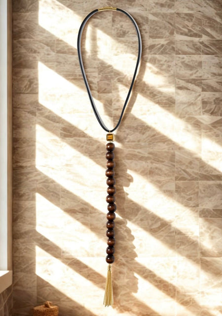 Necklace with beads and tassel on a textured wall