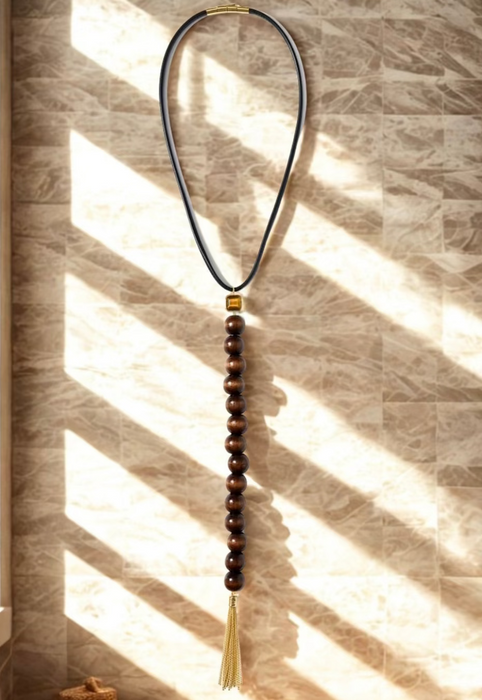 Necklace with beads and tassel on a textured wall