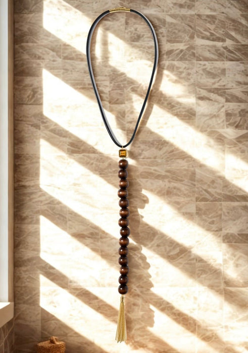 Necklace with beads and tassel on a textured wall