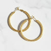 Gold hoop earrings on a white background