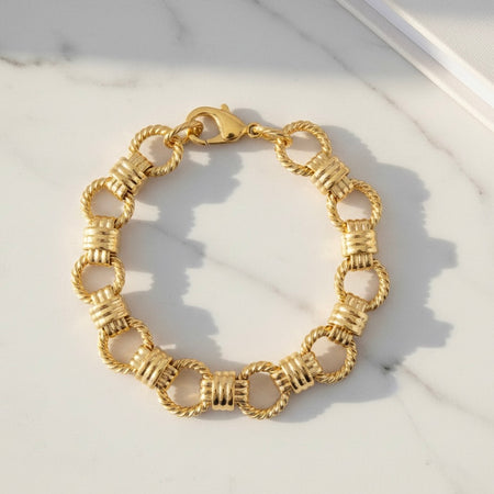 Gold chain bracelet on a marble surface