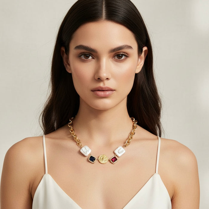 Woman wearing a gold necklace with colorful pendants against a neutral background