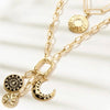 Gold necklace with various charms on a white background