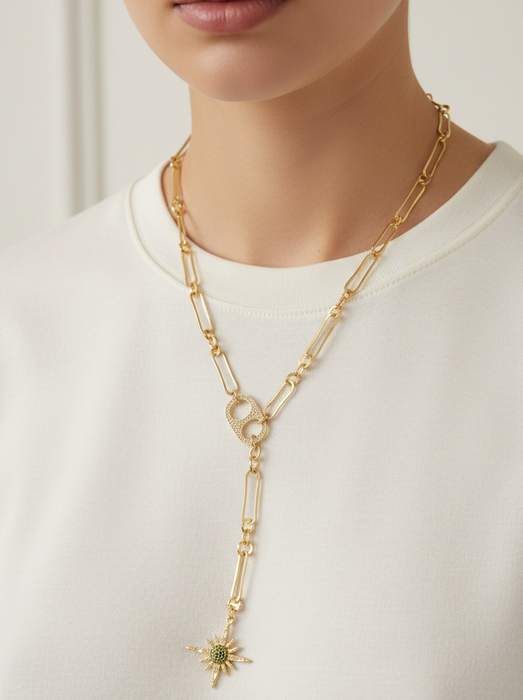 Gold chain necklace with a star pendant worn by a person on a white background
