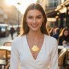 Woman wearing a gold necklace in an outdoor cafe setting