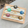 Set of colorful bracelets on a wooden tray with a natural background