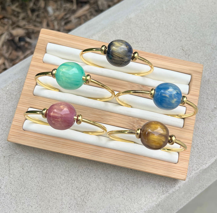 Set of colorful bracelets on a wooden tray with a natural background