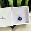 Blue pendant necklace in a white box with 'CF Collection' branding.