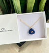 Blue pendant necklace in a white box with 'CF Collection' branding.