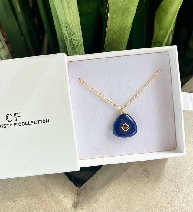 Blue pendant necklace in a white box with 'CF Collection' branding.