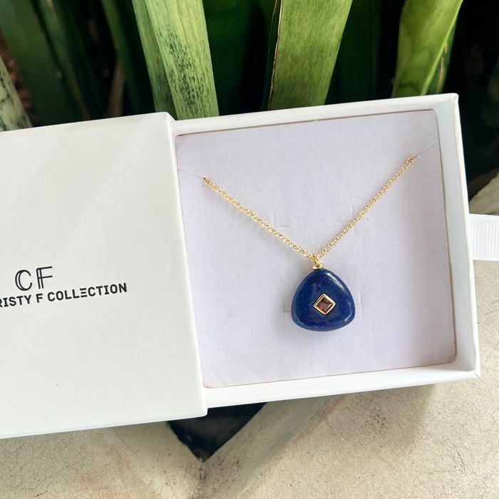 Blue pendant necklace in a white box with 'CF Collection' branding.