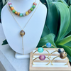Jewelry set with necklace and bracelet on a white stand with green plants in the background