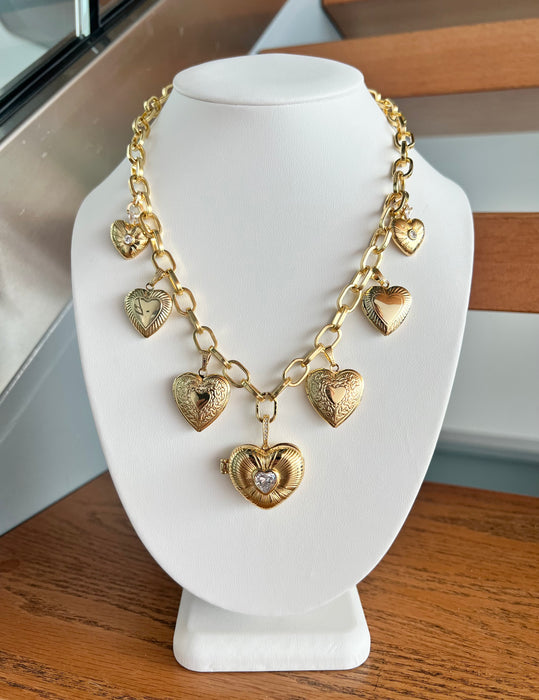 Gold heart-shaped necklace on a white mannequin bust.