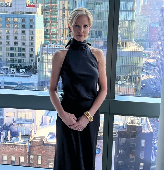 Woman in a black dress standing in front of a cityscape view