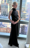 Woman in a black dress standing in front of a cityscape view