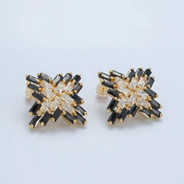 Pair of earrings with black and gold design on a light blue background