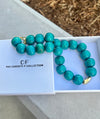 Turquoise beaded necklace with gold clasp on a white box labeled 'The Christy F Collection'.