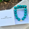 Turquoise beaded necklace with gold accents in a box labeled 'The Christy F Collection'.
