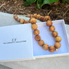 Wooden beaded necklace on a branded box with 'The Christy F Collection' branding.