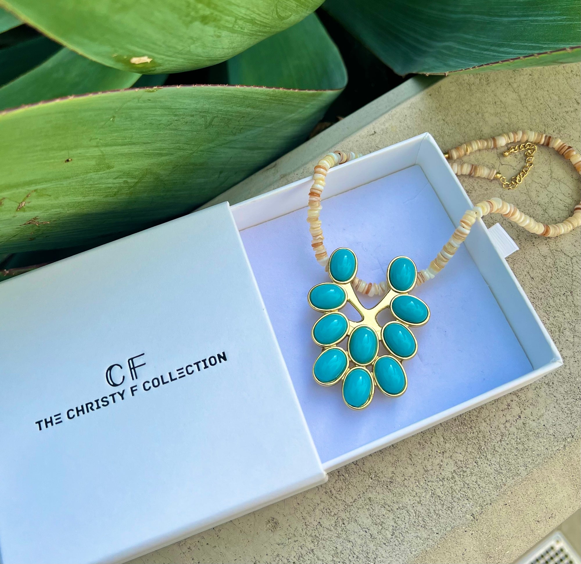 Turquoise necklace with gold accents in a 'The Christy F Collection' box.