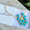 Necklace with turquoise pendant and beaded chain on a white box with 'CF' branding.