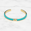 Turquoise bangle with gold accents on a white marble background