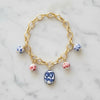 Gold chain bracelet with ceramic beads on a marble surface