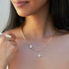 Gold necklace with star-shaped pendants worn by a person