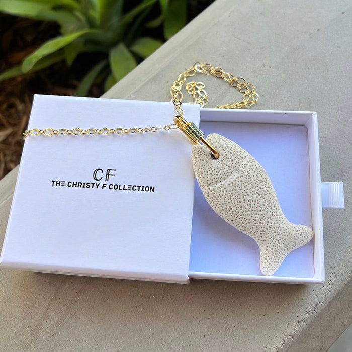 Gold fish-shaped pendant necklace in a box with 'The Christy F Collection' branding.