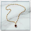 Gold necklace with gemstones on a marble surface